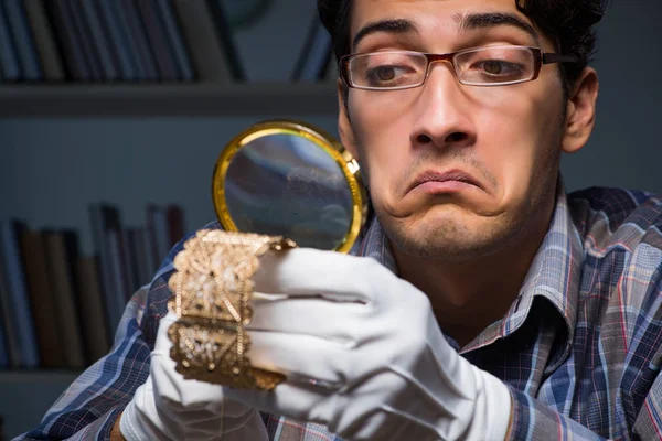 Jonge mannelijke juwelier die 's nachts in zijn atelier werkt — Stockfoto