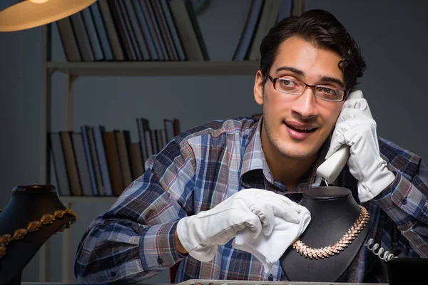 Jonge mannelijke juwelier die 's nachts in zijn atelier werkt — Stockfoto