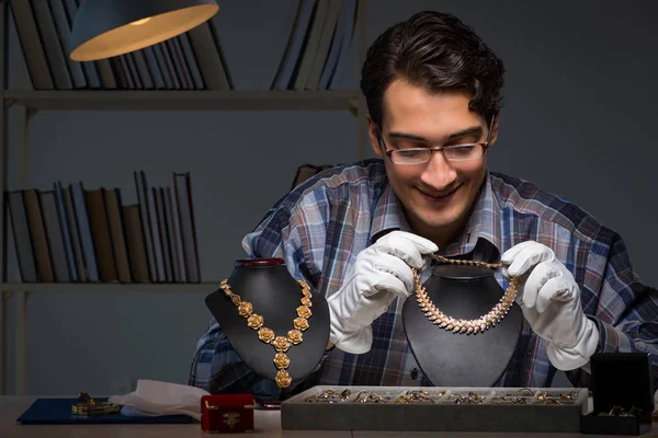 Jonge mannelijke juwelier die 's nachts in zijn atelier werkt — Stockfoto