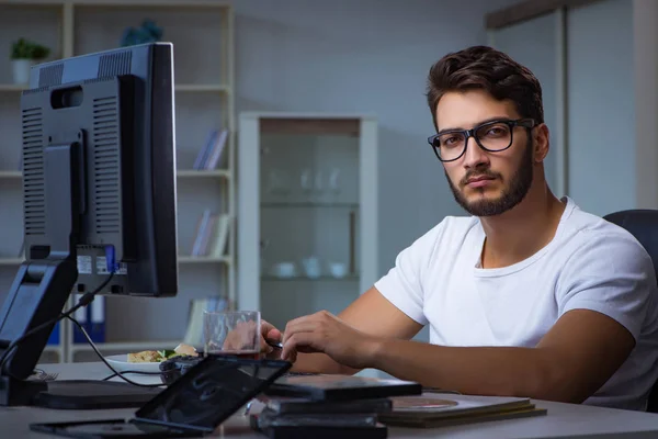 Jongeman die laat op kantoor blijft om overwerk te doen — Stockfoto