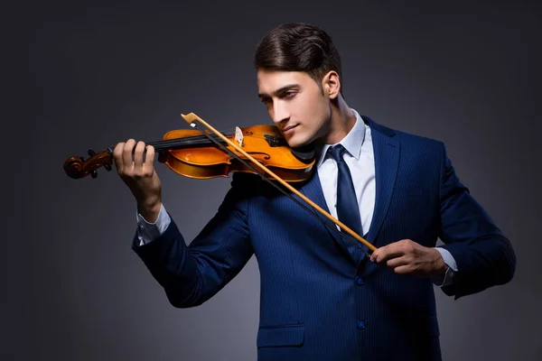 Young man playing violin in dark room — Stock Photo, Image