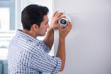 Adam eve güvenlik kameraları yerleştiriyor.