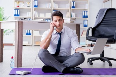 Adam stresle baş etmek için ofiste meditasyon yapıyor.