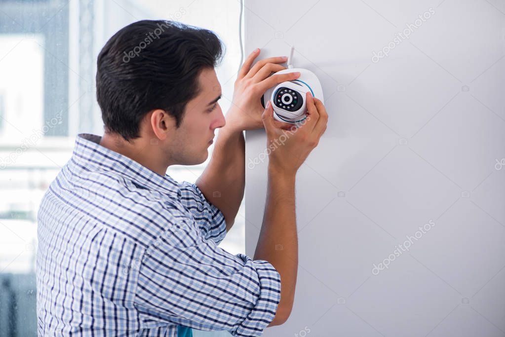 Man installing surveillance CCTV cameras at home