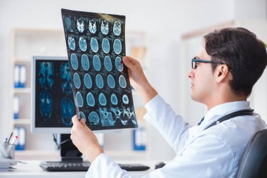 Doktor radyoloji uzmanı röntgen görüntülerine bakıyor.