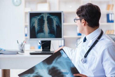 Doktor radyoloji uzmanı röntgen görüntülerine bakıyor.