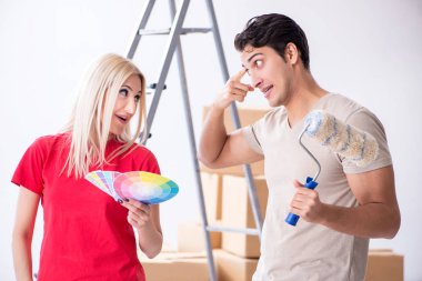 Ev tadilatı sırasında genç bir aile boya işi yapıyor.