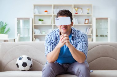 Sanal gerçeklik gözlüğü takan bir adam futbol maçı izliyor.