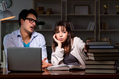 İki öğrenci geç saatlere kadar çalışıp sınavlara hazırlanıyor.