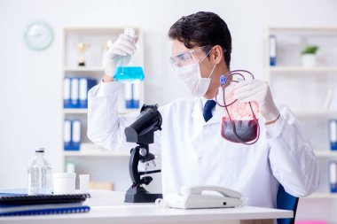 Hastane kliniğinde kan örnekleriyle çalışan bir doktor.