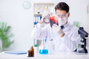 Hastane kliniğinde kan örnekleriyle çalışan bir doktor.