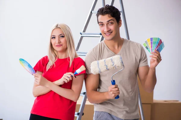 Giovane famiglia che fa lavoro di pittura durante la ristrutturazione della casa — Foto Stock