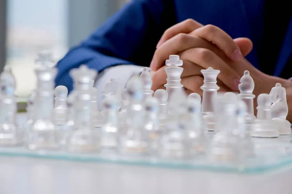 Young businessman playing glass chess in office — Stock Photo, Image