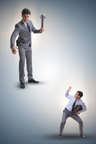 Bad angry boss threatening employee with hammer — Stock Photo, Image