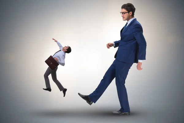 Bad angry boss kicking employee in business concept — Stock Photo, Image