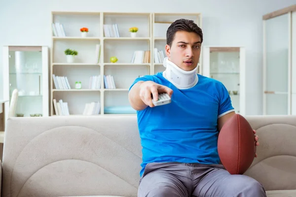 Muž se zraněním krku sledování amerického fotbalu doma — Stock fotografie
