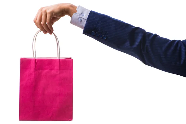Mão segurando sacos de compras com compras de Natal na parte traseira branca — Fotografia de Stock