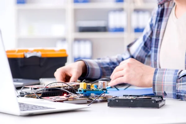 Professional repairman repairing computer in workshop