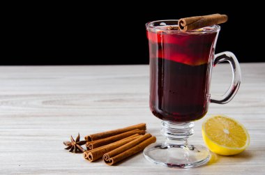 Haşlanmış şarap, yılbaşı masasında servis edilen bardaklarda parlıyor.