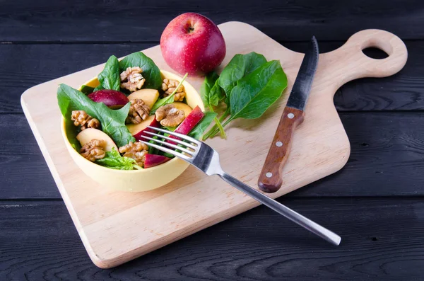 Salada de espinafre com nozes e maçãs servidas na mesa — Fotografia de Stock