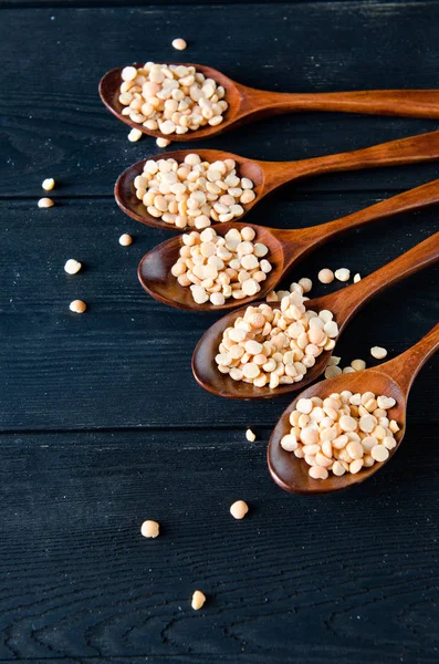 Spoons filled with uncooked lentil for soup — Stock Photo, Image