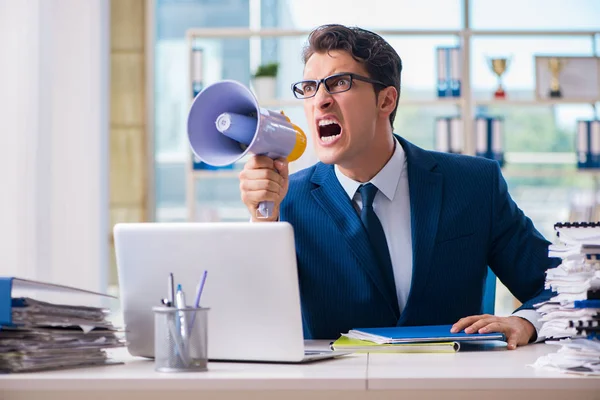 Angry aggressive businessman with bullhorn loudspeaker in office — Stock Photo, Image