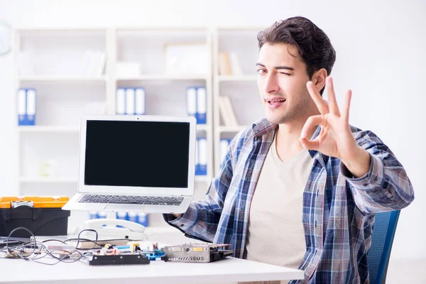 Professional repairman repairing computer in workshop