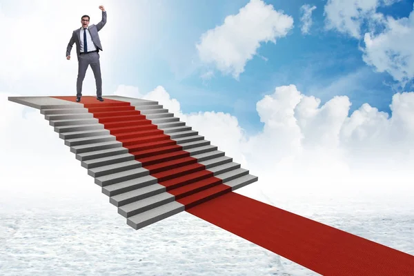 Young businessman climbing stairs and red carpet into sky — Stock Photo, Image