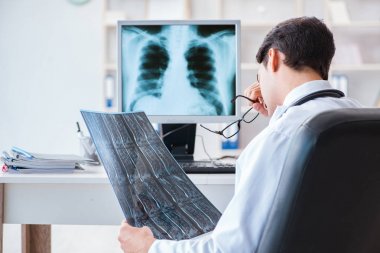 Doktor radyoloji uzmanı röntgen görüntülerine bakıyor.
