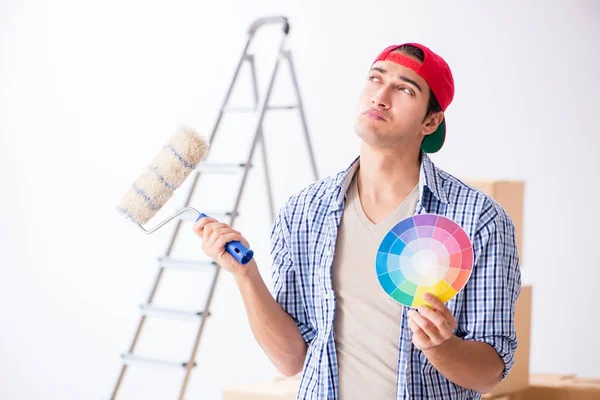 Joven contratista pintor eligiendo colores para la renovación del hogar —  Fotos de Stock