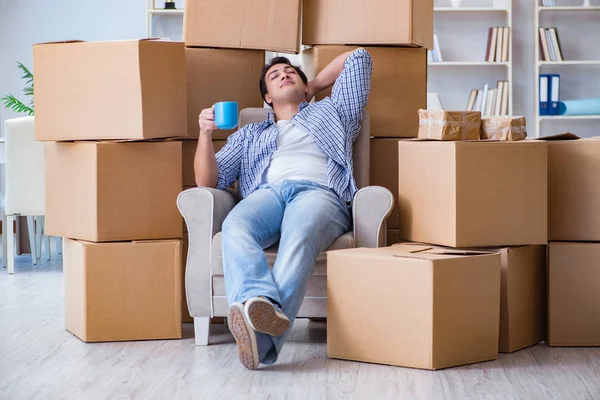 Jovem se mudando para casa nova com caixas — Fotografia de Stock