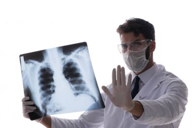 Röntgen görüntülerine bakan genç doktor beyazda izole edilmiş.