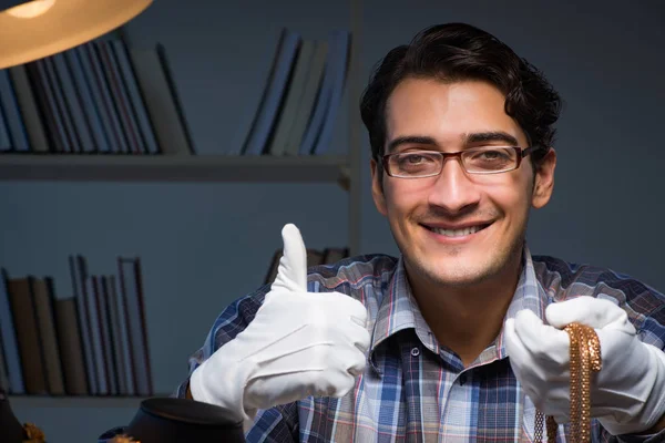 Jonge mannelijke juwelier die 's nachts in zijn atelier werkt — Stockfoto