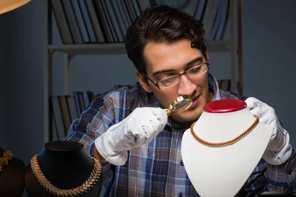 Jonge mannelijke juwelier die 's nachts in zijn atelier werkt — Stockfoto