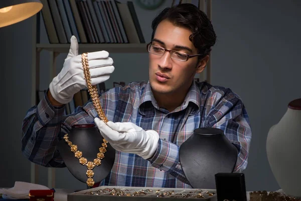 Jonge mannelijke juwelier die 's nachts in zijn atelier werkt — Stockfoto
