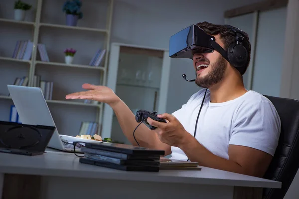 Jovem jogando jogos longas horas atrasado no escritório — Fotografia de Stock