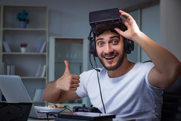 Jovem jogando jogos longas horas atrasado no escritório — Fotografia de Stock