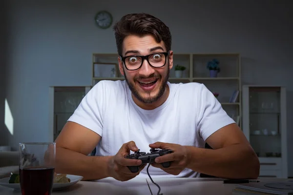 Jovem jogando jogos longas horas atrasado no escritório — Fotografia de Stock