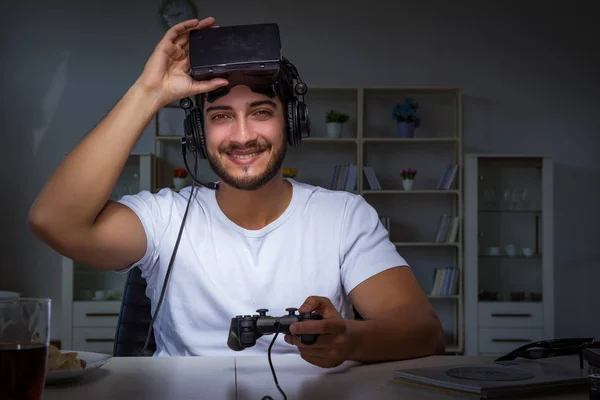 Jeune homme jouant à des jeux longues heures en retard au bureau — Photo