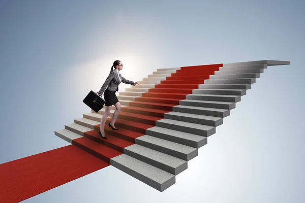 Jovem empresária subindo escadas e tapete vermelho — Fotografia de Stock