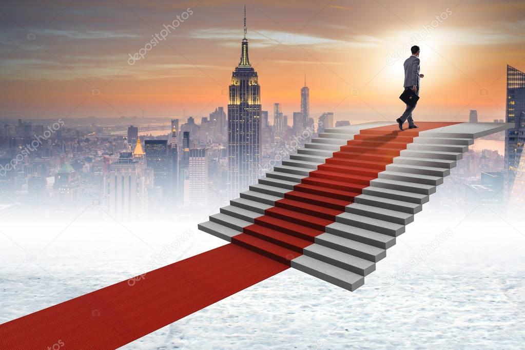 Young businessman climbing stairs and red carpet