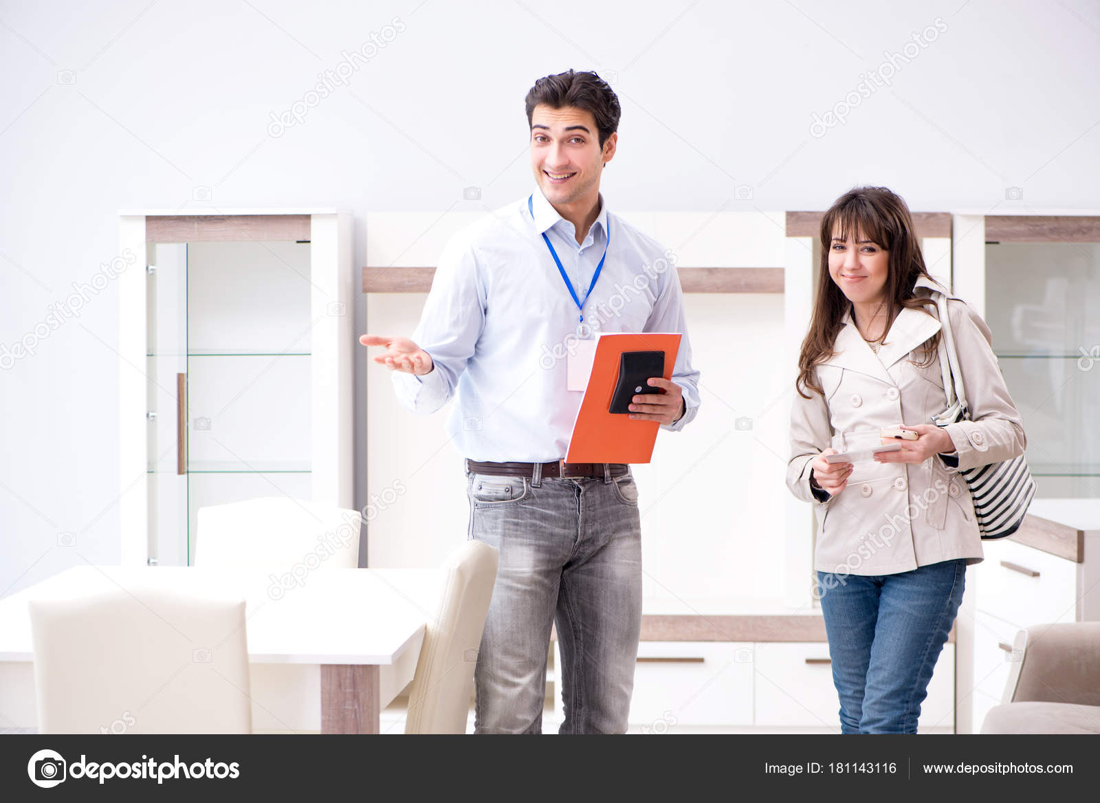 Salesman explaining to woman customer at furniture store Stock Photo by