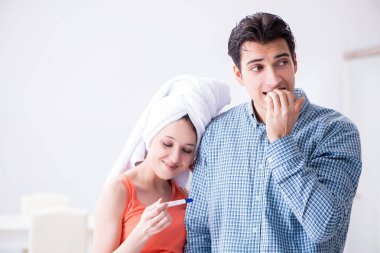 Wife and husband looking at pregnancy test clipart