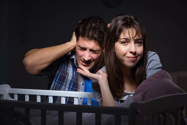 Jovens pais sem sono com bebê recém-nascido à noite — Fotografia de Stock