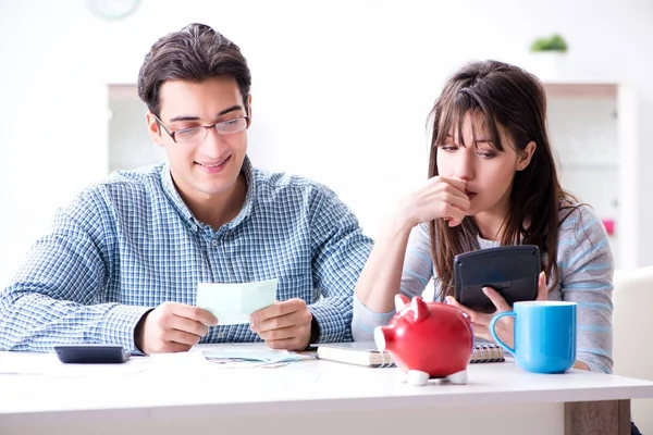 Junges Paar schaut auf Familienfinanzierungspapiere — Stockfoto