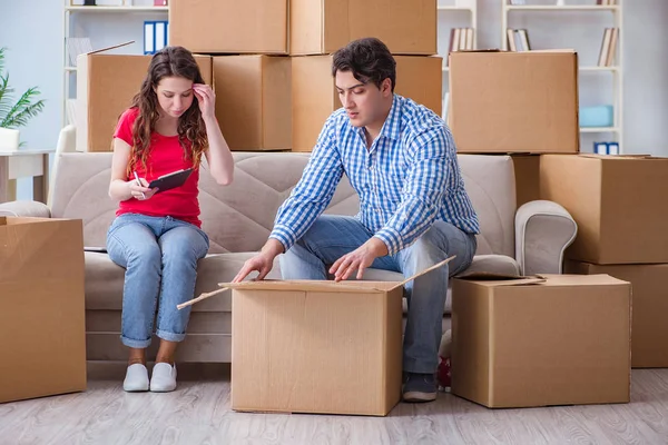 Молодая пара переезжает в новый дом с коробками — стоковое фото