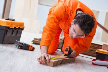 Müteahhit lamine ahşap zemin üzerinde çalışıyor.