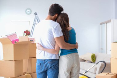 Yeni evdeki kutuları açan genç bir aile.