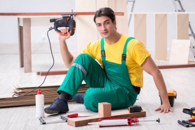 Müteahhit lamine ahşap zemin üzerinde çalışıyor.