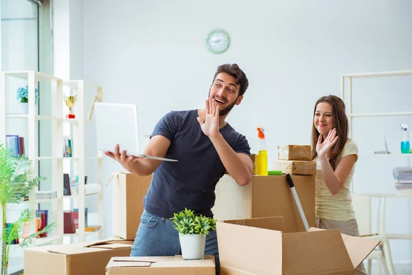 Jonge familie uitpakken bij nieuw huis met dozen — Stockfoto